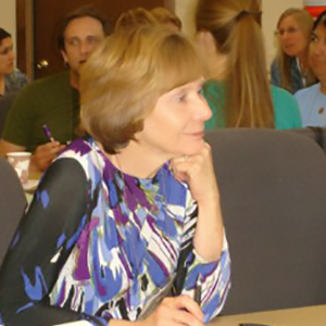 Woman holding her hand to her chin and listening.