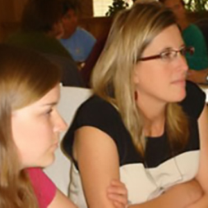 Two women listening and looking in one direction.