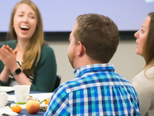 three people talking and smiling.