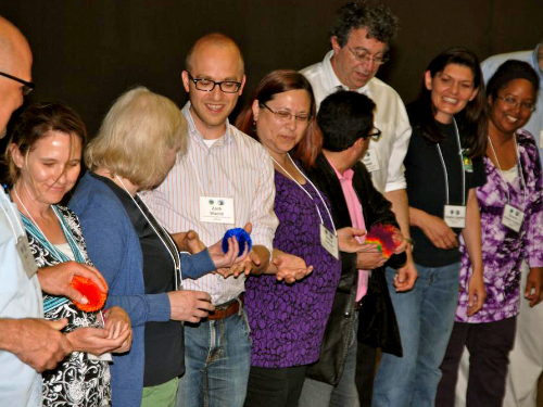 People standing in a line passing a ball to each other.