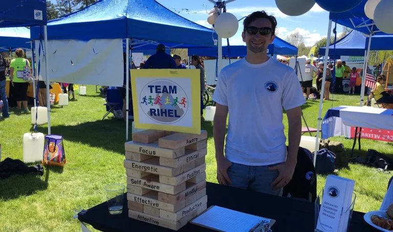 RIHEL Volunteer Rick standing underneath an event tent