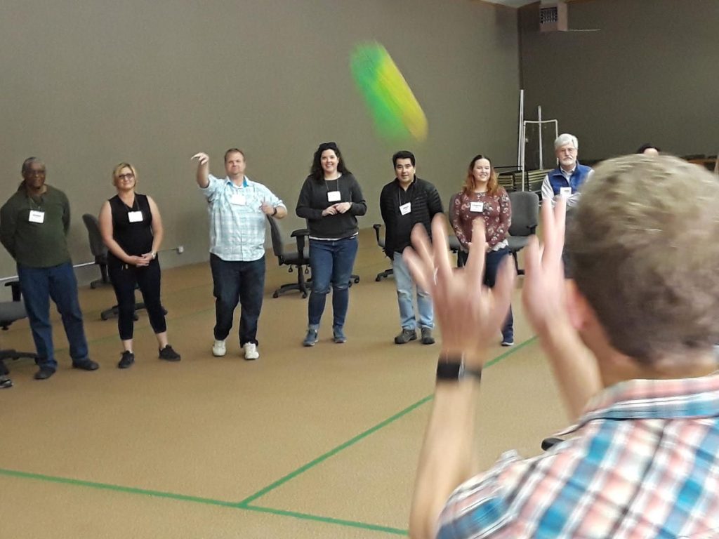 Group of people tossing a ball to each other.
