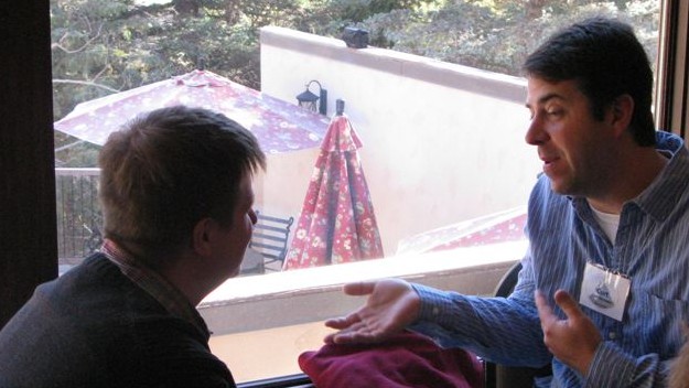 Two men sitting by a window