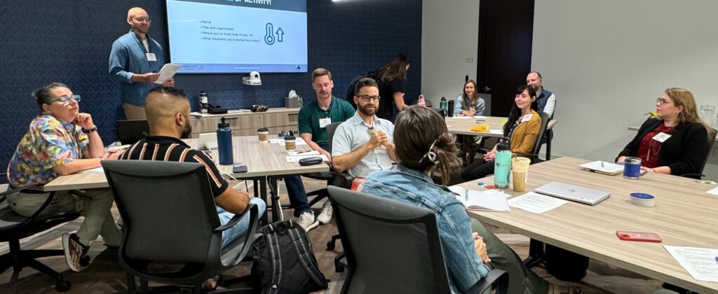 People sitting in small groups at tables during a workshop.